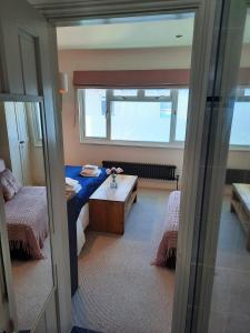 a room with a bed and a table and a window at Super king bedroom with large ensuite in Brighton & Hove +7 photos