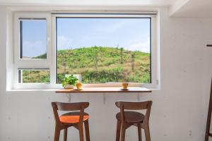 two chairs sitting in front of a window at Gangneung Dao Pool Villa in Gangneung