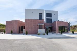 a red brick building with a white cube at Gangneung Dao Pool Villa in Gangneung