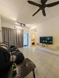 Una sala de estar con un sofá y un ventilador de techo. en Garden Homes Seremban 2 644, en Seremban