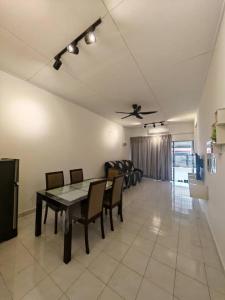 Una sala de estar con una mesa y sillas y un sofá. en Garden Homes Seremban 2 644, en Seremban