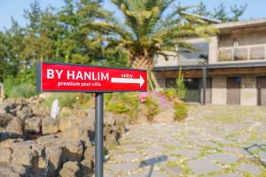a red sign in front of a building at By Hanlim in Jeju
