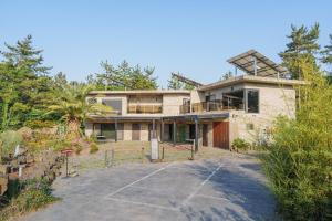 a large house with a driveway in front of it at By Hanlim in Jeju