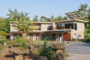 a house with a windmill on top of it at By Hanlim in Jeju +24 photos
