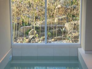a window in a bathroom with a view of a garden at Jeju Seochae in Seogwipo