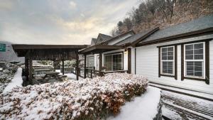 a house with snow on the ground in front of it at Hongcheon Anga Inn Pension in Hongcheon