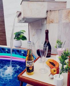 - une bouteille de bière et un verre à côté de la piscine dans l'établissement Piscina e Churrasqueira - 8 minuto a pé da Praia, à Mongaguá 42 autres photos
