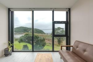 a living room with a couch and a large window at Trip Recipe in Jeju +23 photos
