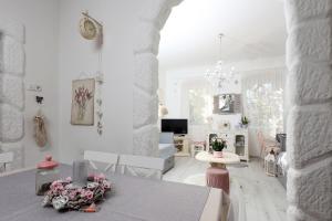 a white living room with a table and chairs at House Ingrid in Rijeka