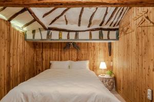 a bedroom with a white bed in a wooden wall at Jeju Wooden Attic Pension in Namŭm-ni