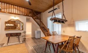 a dining room with a wooden table and a staircase at Jeju Wooden Attic Pension in Namŭm-ni