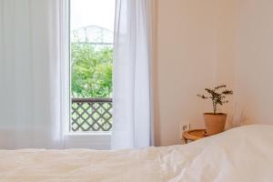 a bedroom with a bed and a window with a potted plant at Jeju Wooden Attic Pension in Namŭm-ni +25 photos
