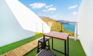 een balkon met een tafel en uitzicht op het water bij Geoje Star Marine Pool Villa in Geoje  +7 foto's