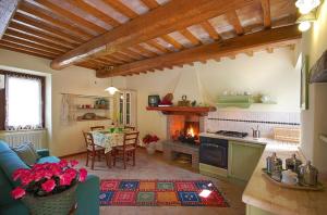 a kitchen and living room with a table and a fireplace at Green House - Blue House in Civitella dʼAgliano