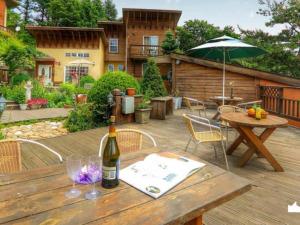 a wooden table with a bottle of wine on a deck at Queens Garden Pension in Pyeongchang