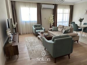 a living room with a couch and chairs and a table at Sokon Residence Madinaty in Madinaty