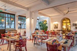 a restaurant with wooden tables and red chairs at Le Grand Hôtel in Molitg les Bains
