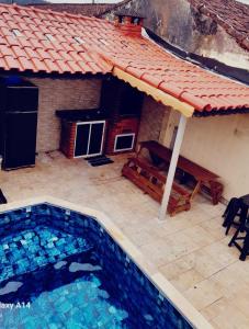 une piscine devant une maison dans l'établissement Piscina e Churrasqueira - 8 minuto a pé da Praia, à Mongaguá