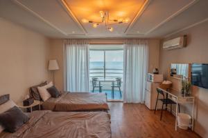 a bedroom with two beds and a view of the ocean at Aewoleui Ondo in Jeju