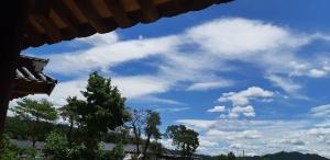 una vista su un cielo azzurro con nuvole e alberi di Manhoe Gotaek a Bonghwa