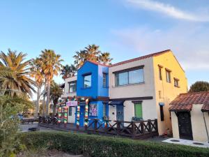 a colorful house on a street with palm trees at Lime Orange Vill in Seogwipo