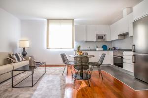 een keuken en een woonkamer met een tafel en stoelen bij Slow Suites Augusto in Madrid