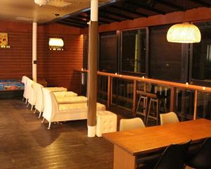 a room with white chairs and a table and a bar at Gapyeong Pop Pension in P'yŏngban-ni