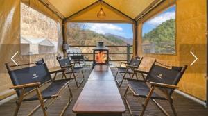 a tent with a table and chairs and a fireplace at Gapyeong Pop Pension in P'yŏngban-ni
