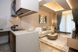 a kitchen and living room with a couch and a table at One Bedroom Luxury Apartment at The Diamond in the City in Accra