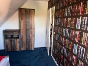 a room with a wall full of books at Landhaus Upn Wall mit Ponyreiten und Kutschfahrten in Mettingen