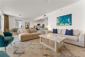 a living room with two couches and a table at Tides 611 in Destin