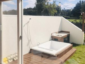 a bath tub sitting on a deck with a sink at Wasan Stay in Jeju in Jeju