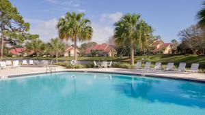 una gran piscina con sillas y palmeras en Beachwalk Villa 5135, en Destin