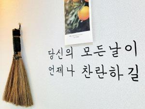 a broom on a wall next to a picture at Jeju Hyeopjae Life in Jeju +11 photos