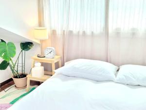 a bedroom with a bed and a clock on a table at Jeju Hyeopjae Life in Jeju