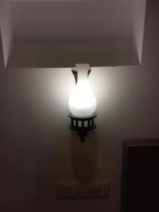 a light on a wall with a lamp on it at Marari Beach Way Inn in Alleppey