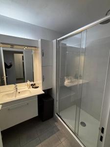 Un baño con ducha de cristal y lavabo. en Appartamento in riva al mare a Cannes, en Cannes