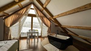 a bedroom with a large window and a bath tub at Cabana Huta Slavia in Şinteu