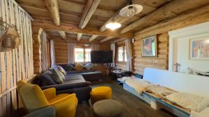 a living room in a log cabin with a couch and chairs at Cabana Huta Slavia in Şinteu