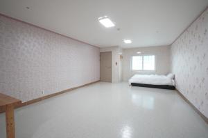 a large white room with a bed in it at Sungbochon Youth Hostel - Hostel in Mungyeong +4 photos