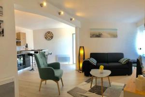 a living room with a couch and a table at Jolie maisonnette cosy Bord de mer Terrasse in Guidel