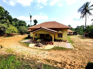 a small house in the middle of a field at Malnad Bliss in Sringeri