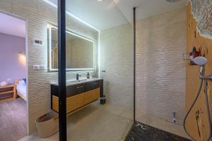 a bathroom with a sink and a glass shower at Ty-Gwenn - Grande Maison de campagne familiale in Surzur