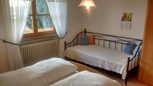 two beds in a room with a window at Schneiderhof in Steinbach