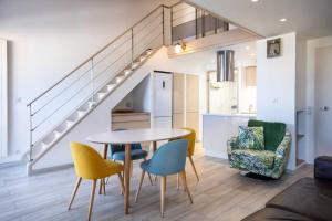 ein Wohnzimmer mit Tisch und Stühlen und einer Treppe in der Unterkunft La Misaine, les Minimes, LR117 in La Rochelle