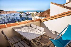 einen Tisch und Stühle auf dem Balkon eines Gebäudes in der Unterkunft La Misaine, les Minimes, LR117 in La Rochelle