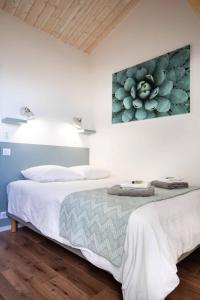 zwei Betten in einem Zimmer mit einem Gemälde an der Wand in der Unterkunft La Misaine, les Minimes, LR117 in La Rochelle + 10 Fotos