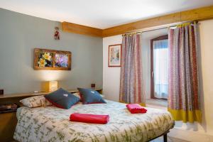 a bedroom with a bed with two red pillows on it at Maison Cerise Pila in Gressan