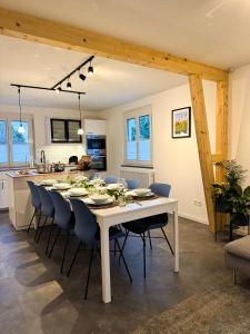 a dining room and kitchen with a white table and chairs at Modernes Ferienhaus Böblingen bis 8 Personen in Böblingen