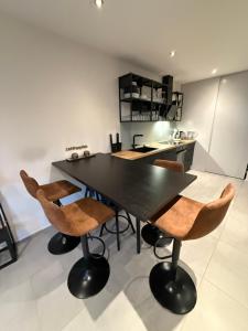a dining room with a black table and chairs at Schönes City Design Apartment I Boxspring I P I Smart I Wasch I 200m Bahnhof in Ibbenbüren +10 photos